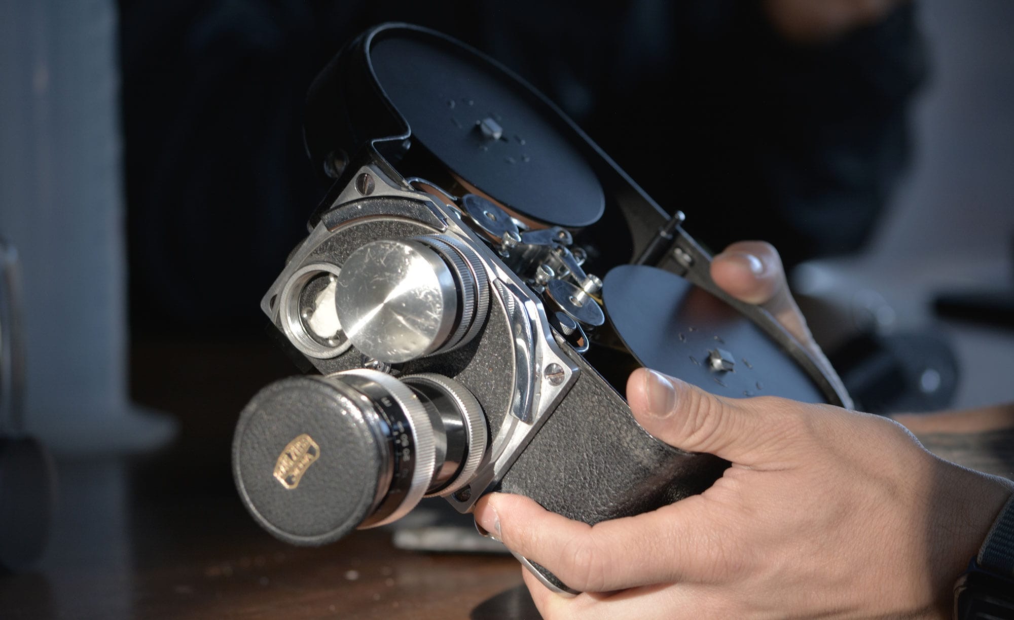 Manos sostienen una cámara de cine de 16 mm